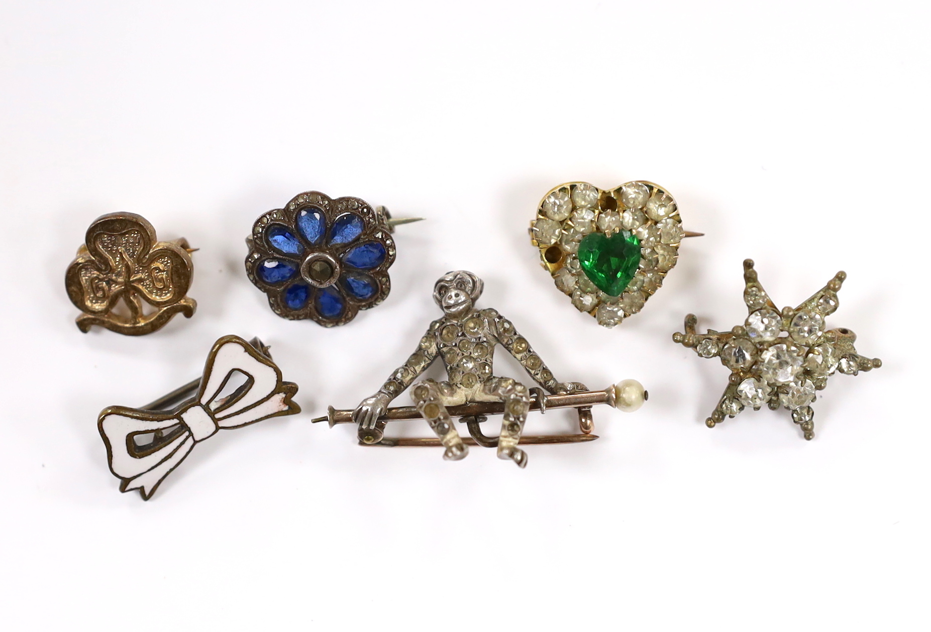 A 9ct and two colour paste set heart shaped brooch, width 15mm and five other assorted brooches, including blue paste and marcasite, paste set seated monkey and paste set starburst.